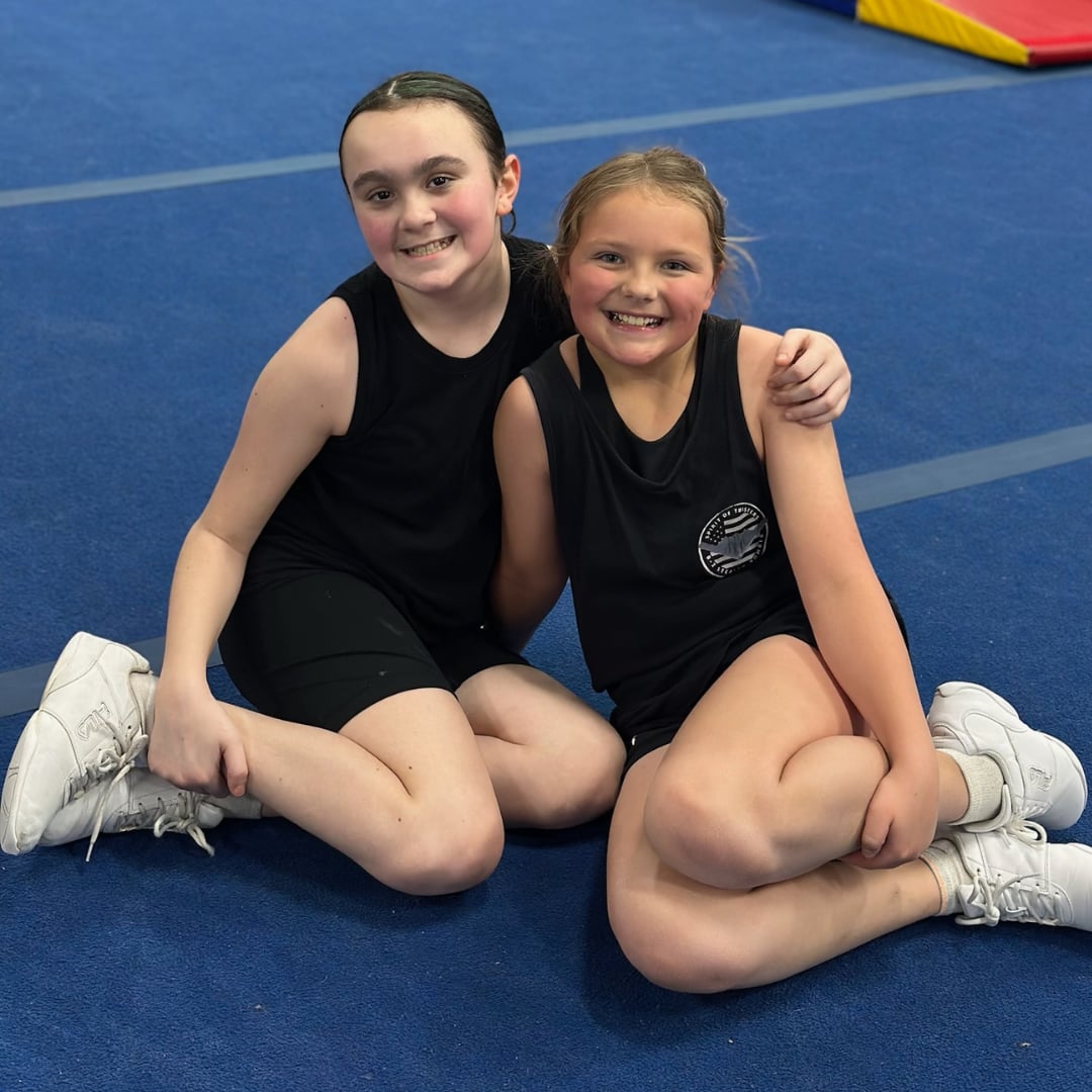 Two cheer and dance athletes smiling together
