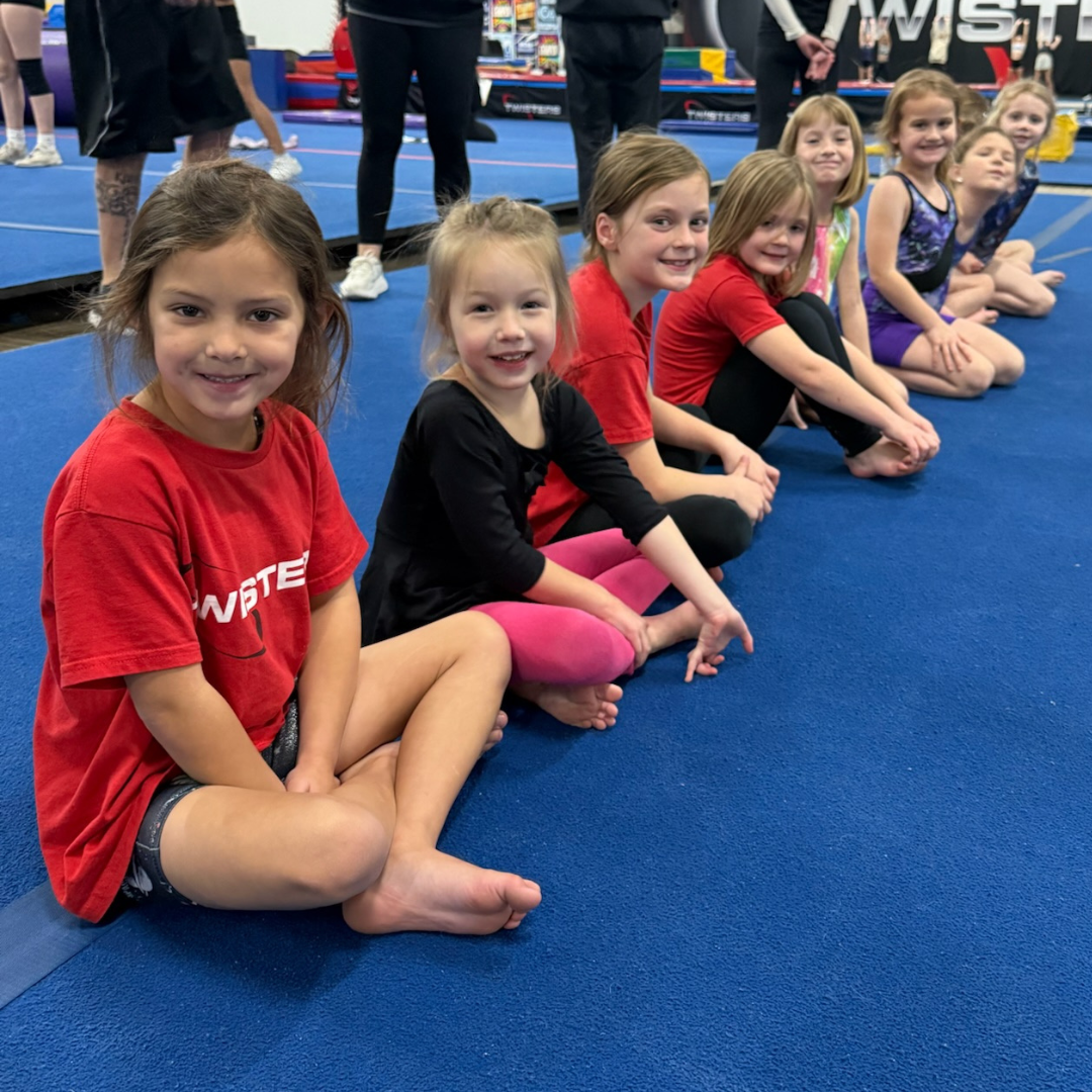 Young Twisters athletes sitting together on the gym floor