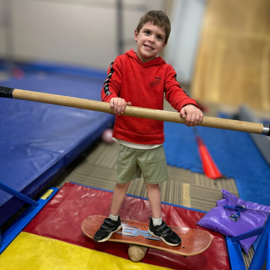 Young athlete balancing on a board in the gym